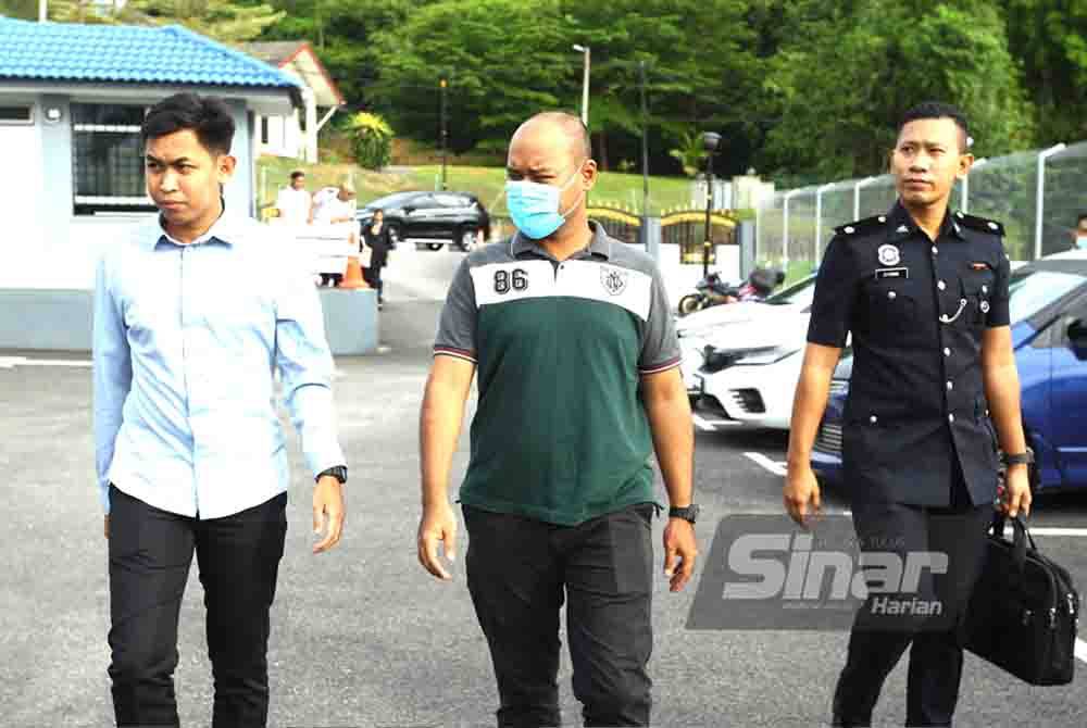 Hasry Hisyam (tengah) diiring polis ketika hadir ke Mahkamah Sesyen Kuala Pilah pada Rabu.