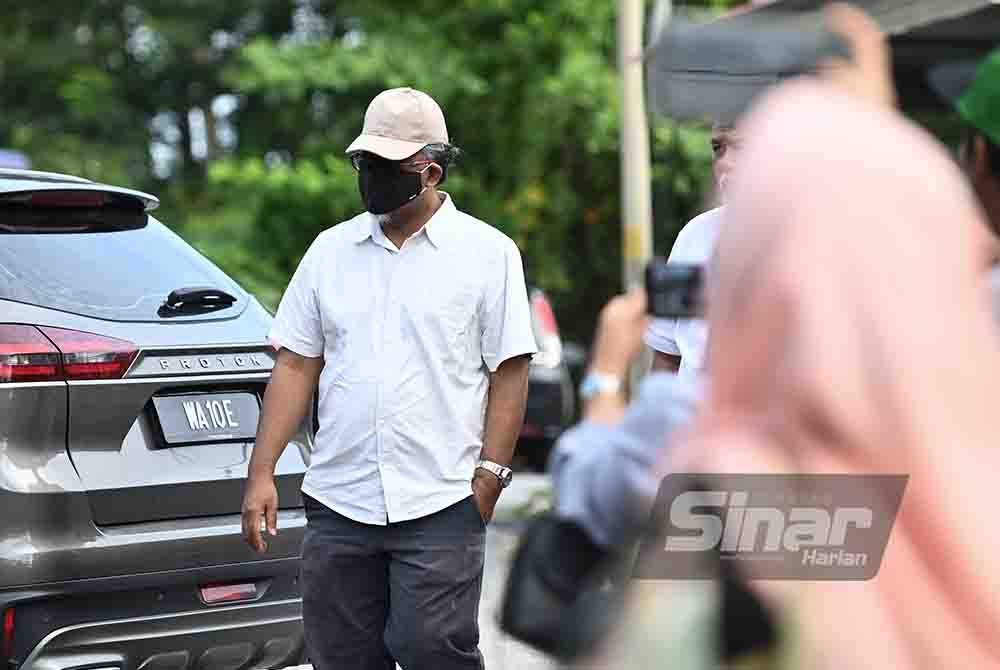 Muhamad Reze (kiri) dihadapkan ke Mahkamah Majistret Marang atas dakwaan memalsukan sijil vaksinasi Covid-19 pelanggan dua tahun lalu.