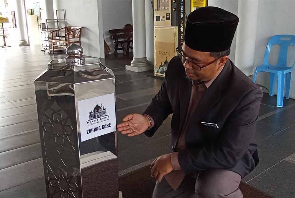 Mohd Naim menunjukkan pelekat khas fungsi tabung yang diperkenalkan pada November lepas.