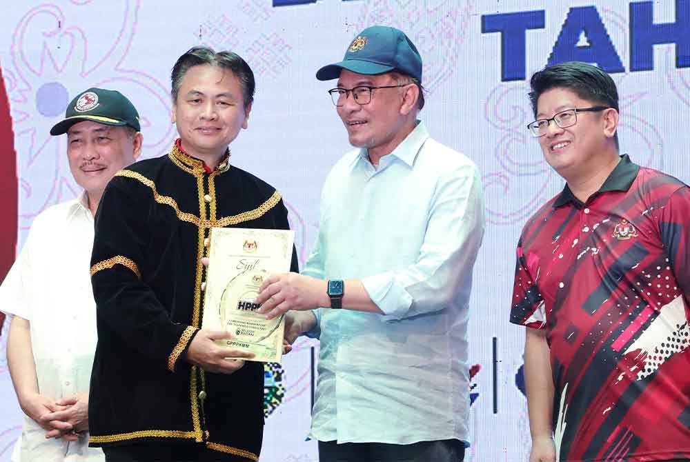 Anwar meletakkan “Wakid” sebagai simbolik perasmian Karnival Hari Penjaja dan Peniaga Kecil Peringkat Kebangsaan di Dataran Buhavan Square Penampang hari ini. - Foto Bernama