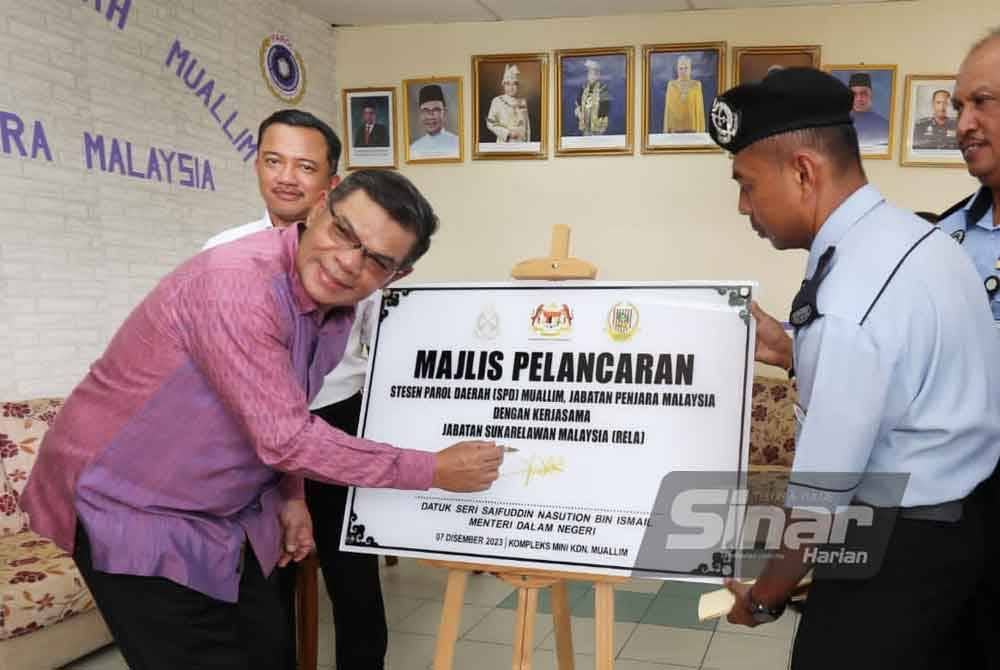 Saifuddin Nasution menandatangani plak simbolik merasmikan SPD di Kompleks Mini KDN di Slim River.