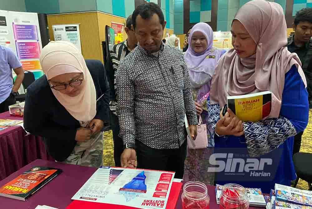 (Dari kiri) Azulita dan Lokman meluangkan masa mengunjungi reruai Rasuah Busters sempena sambutan Hari Integriti LPP 2023 dengan tema 'Bukan Lupa Tapi Tak Ingat' di Kuala Lumpur pada Khamis.