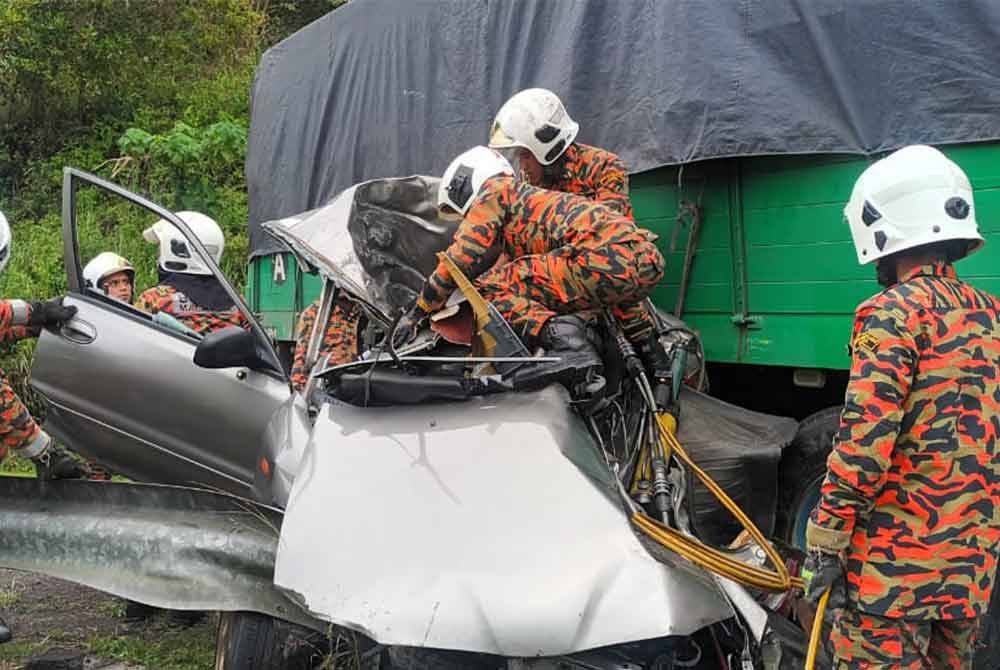 Pasukan bomba menjalankan operasi mengeluarkan kedua-dua mangsa kemalangan di Gerik pada Khamis. - Foto ihsan Bomba Perak