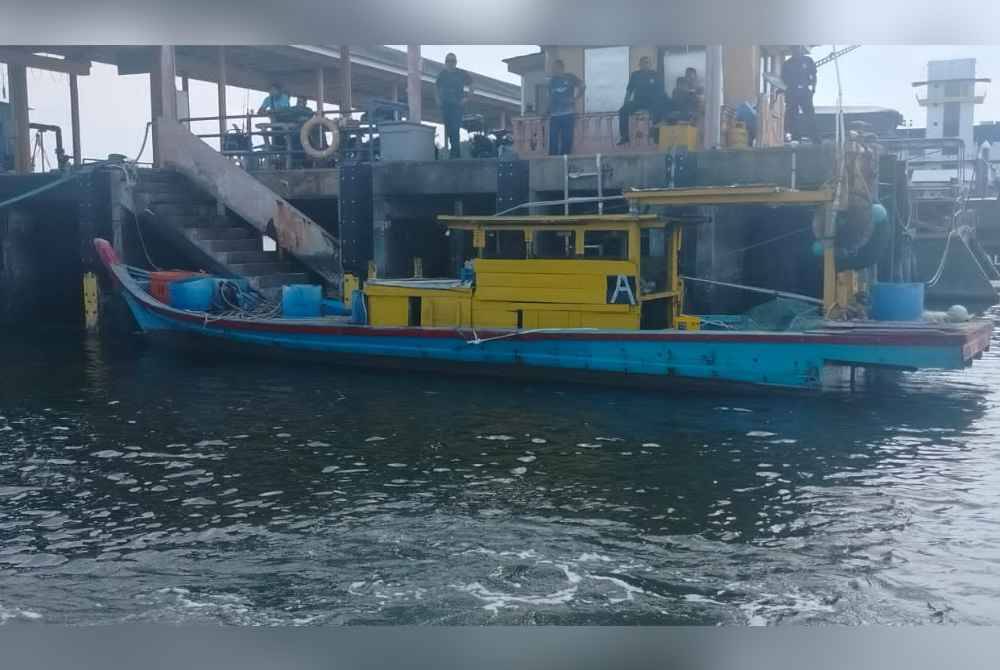 Bot nelayan tempatan ditahan Jabatan Perikanan selepas dikesan menjalankan aktiviti tunda haram di perairan Sungai Burung, Bagan Datuk. - Foto Jabatan Perikanan