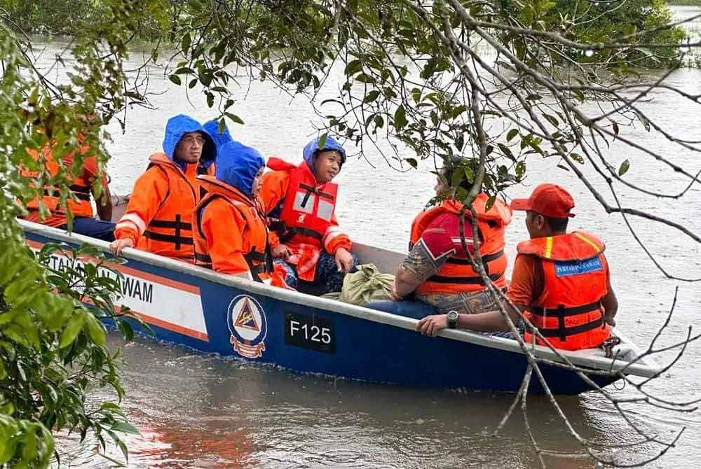 Anggota APM Kelantan melakukan lawatan serta agihan bakul makanan di kawasan yang masih ditenggelami banjir. - Foto APM