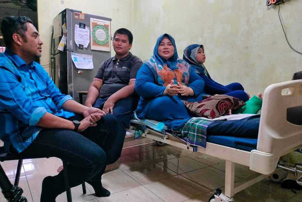 Mohd Noor (kiri) ketika menziarahi tiga beranak itu di Taman Desa Duyong, di sini, pada Jumaat.