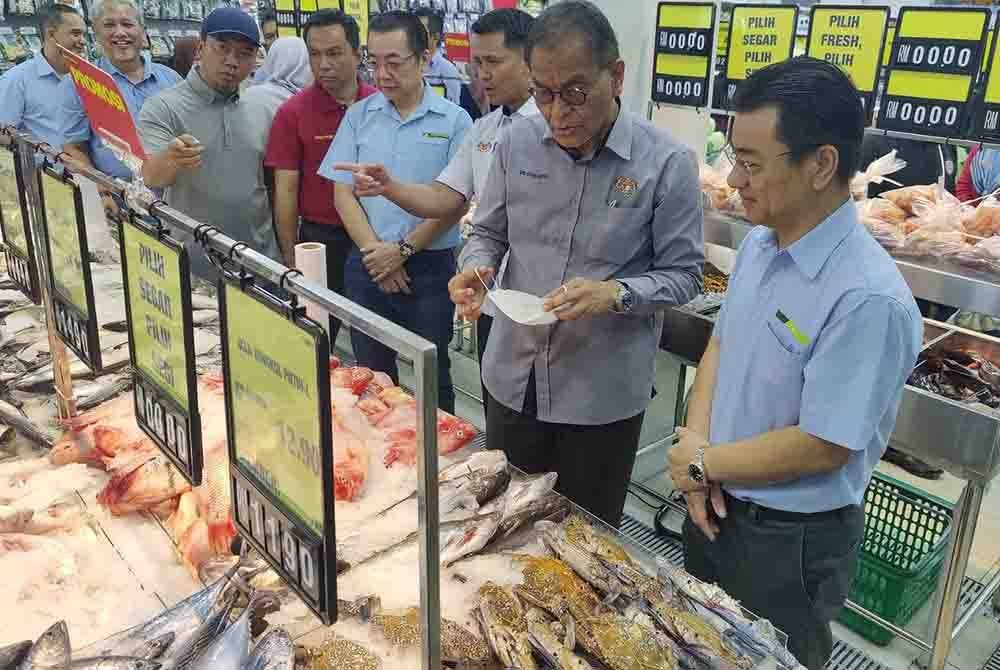 Dzulkefly (dua dari kanan) meninjau barangan yang dijual selepas Majlis Perasmian Cawangan Segi Fresh ke-100 di Ijok, Kuala Selangor pada Sabtu.