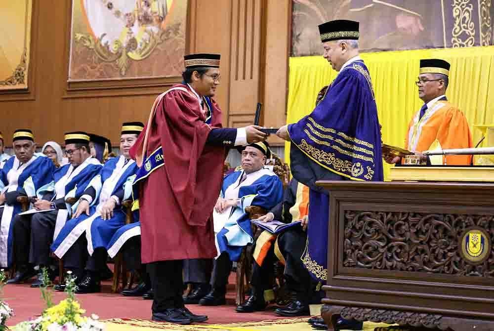Sultan Nazrin berkenan menyampaikan Anugerah Tuanku Canselor kepada Mohamed Aiedil Putera pada Istiadat Konvokesyen USAS ke-16 di Dewan Jubli Perak pada Sabtu. - Foto Bernama