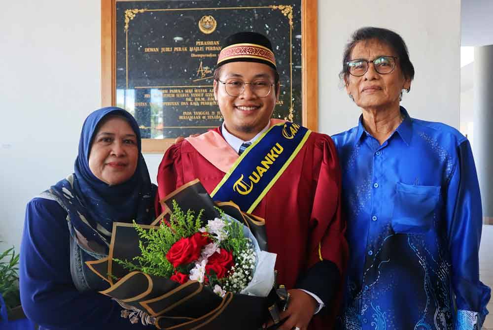 Mohamed Aiedil Putera (tengah) di samping ibu bapanya yang hadir sempena Istiadat Konvokesyen Universiti Sultan Azlan Shah (USAS) ke-16 di Dewan Jubli Perak, Kuala Kangsar pada Sabtu.