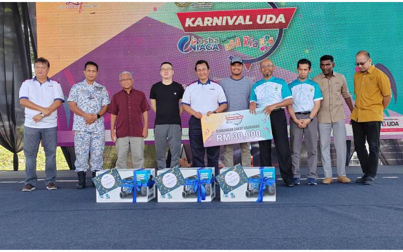 Mohd Salem bergambar bersama wakil penerima sumbangan zakat UDA dan pelanggan setia hartanah UDA yang menerima cenderahati penghargaan.