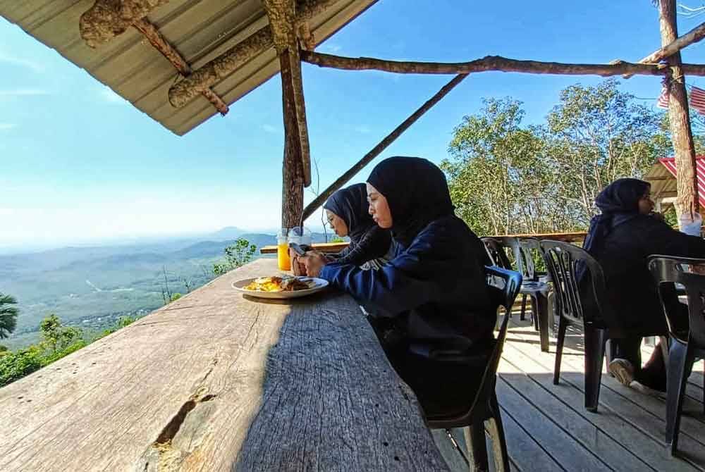 Pengunjung menikmati juadah sambil menikmati keindahan alam