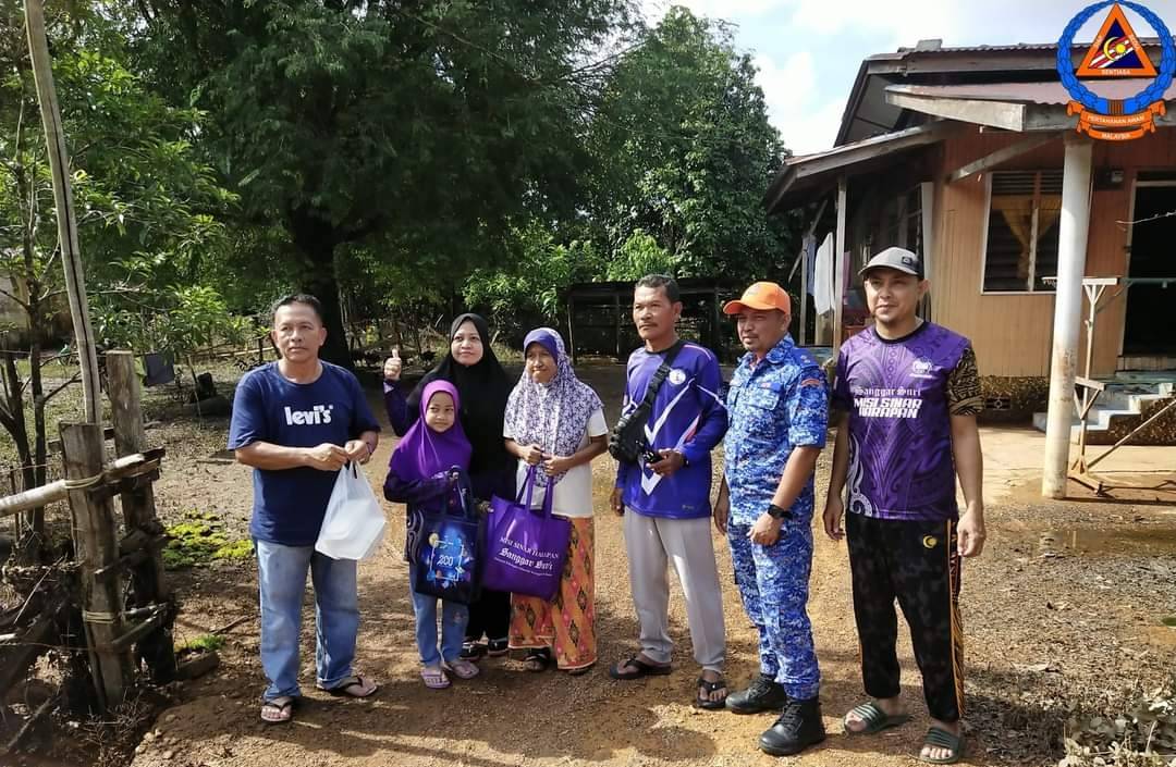 Anggota APM bersama NGO mengagihkan bantuan kepada penduduk yang terjejas banjir.