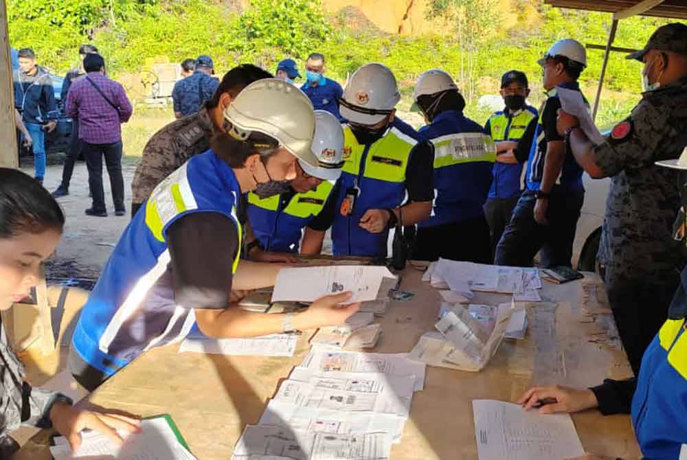 Pegawai JTKSM dan Jabatan Imigresen memeriksa dokumen milik pekerja asing dalam Op Penguatkuasaan Perburuhan Bersepadu di Laluan Meru Indah pada Isnin.