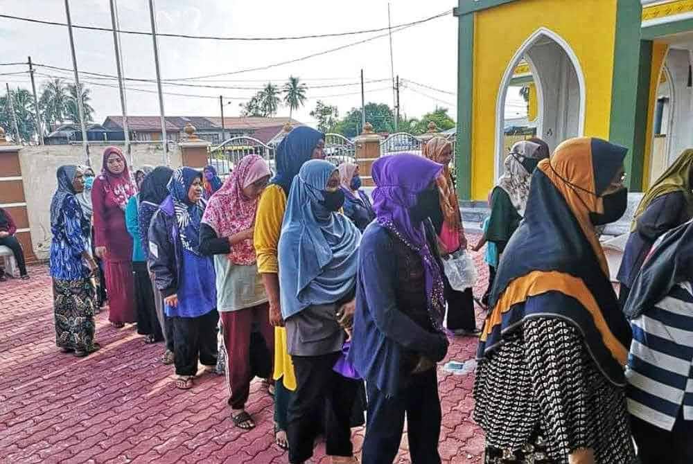 Penduduk sedang beratur untuk mendapatkan beras cupak di Masjid Ar-Rahman Kerpan.