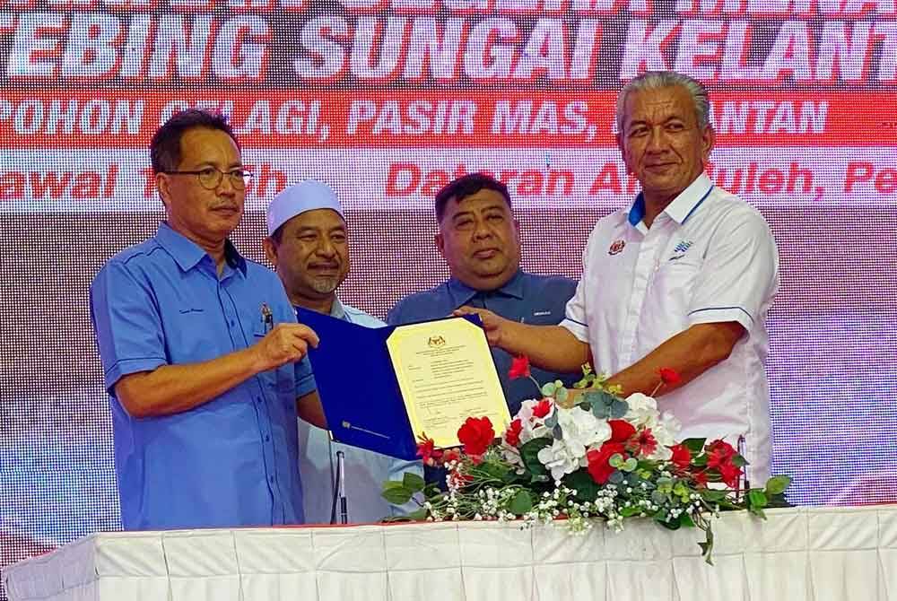 Mohd Nassuruddin (dua dari kiri) menyaksikan penyerahan dokuman pada Majlis Penyerahan Projek Pelaksanaan Segera Menangani Runtuhan Tebing Sungai Kelantan di Kampung Pohon Celagi, Pasir Mas pada Selasa.