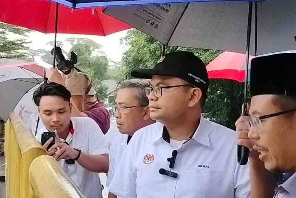 Akmal Nasrullah (tengah) melawat Rumah Pam Kampung Md Amin, pada Selasa.