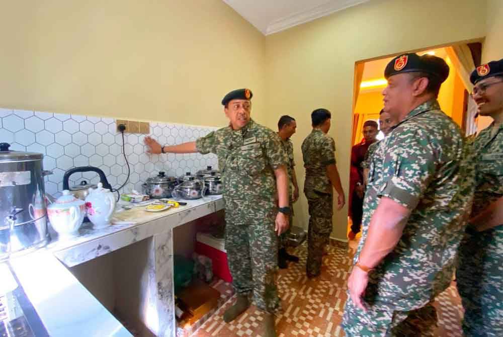 Azhan (kanan) melihat ruangan dapur yang telah siap dibina.