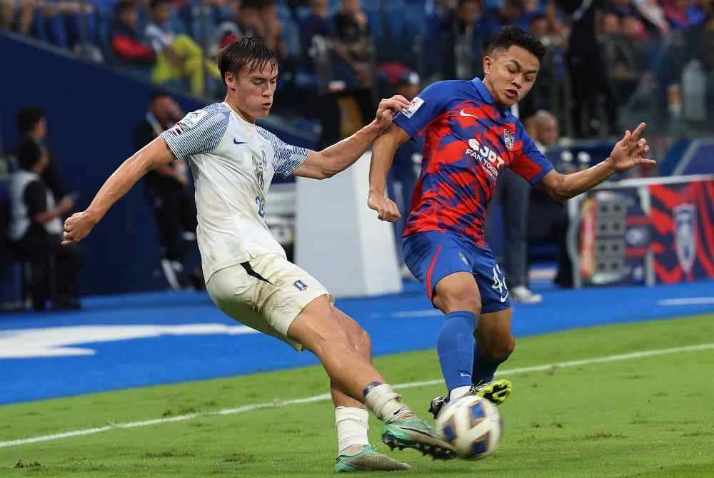 Pemain JDT, Arif Aiman Hanapi mengasak pemain BG Pathum United, Ryhan Stewart pada perlawanan Liga Juara-Juara Asia (ACL) bagi kumpulan I di Stadium Sultan Ibrahim hari ini. - Foto Bernama