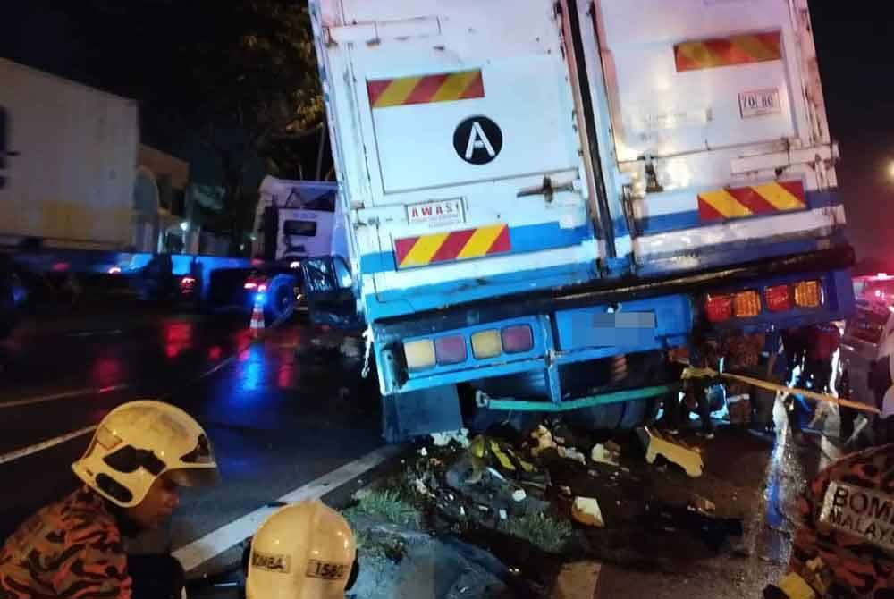 Pasukan bomba sedang menjalankan operasi membawa keluar mangsa yang tersepit di bawah lori kontena berkenaan.