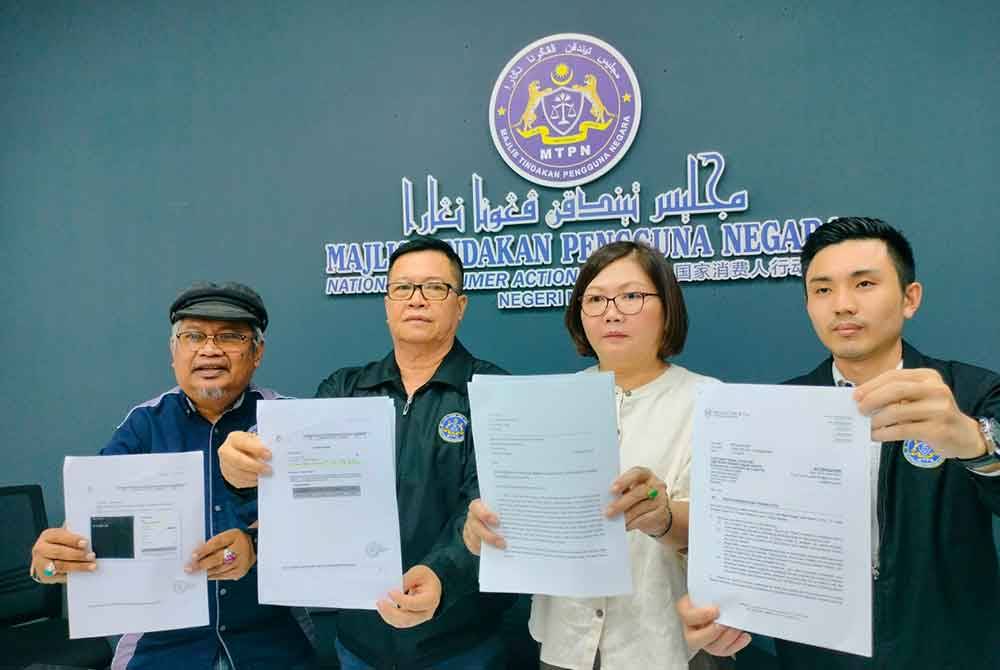Aalex dan Saw Yong (tiga dari kiri) menunjukkan salinan laporan yang telah dibuat di pejabat MTPN Melaka di Kota Laksamana Jaya, Melaka pada petang Selasa.