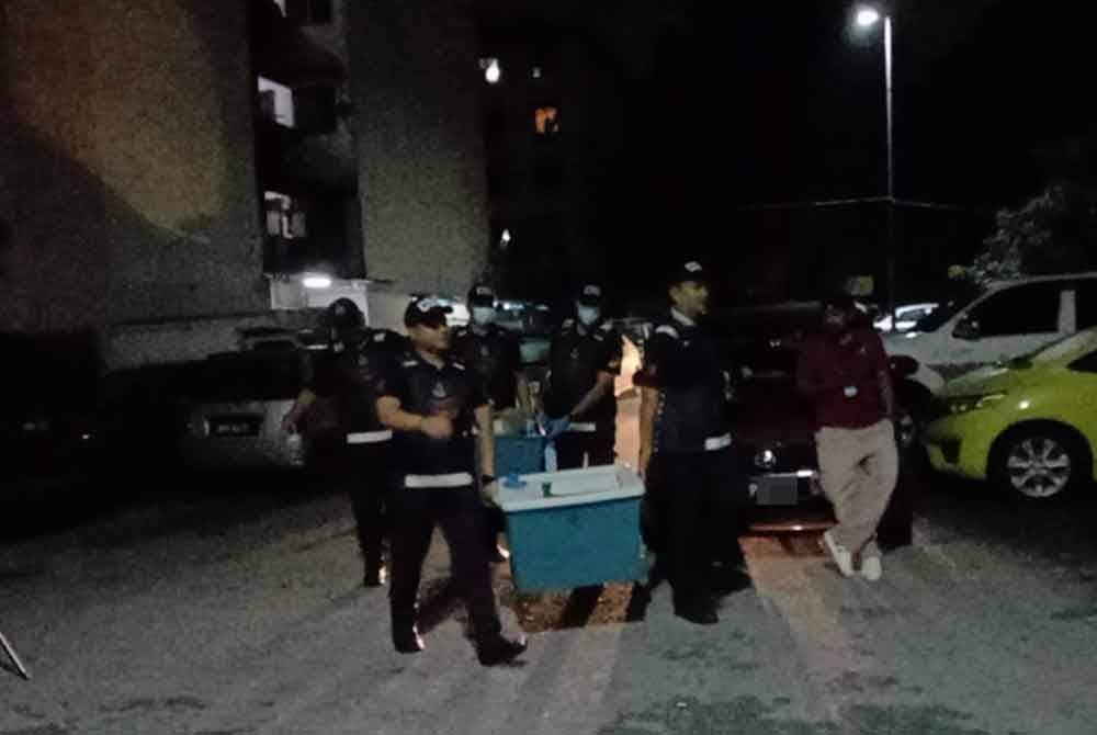 Beberapa anggota polis dilihat keluar dari kawasan Blok R, Apartment Idaman, Damansara Damai pada Selasa.