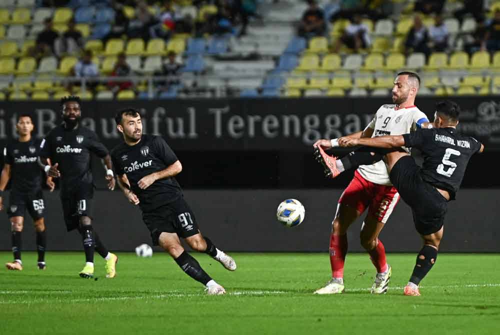 Pemain Terengganu FC, Muhammad Shahrul Nizam (kanan) mengasak pemain Bali United FC, Ilija Spasojevic (dua, kanan) pada perlawanan Piala AFC di Stadium Sultan Mizan Zainal Abidin malam Rabu. - Foto Bernama