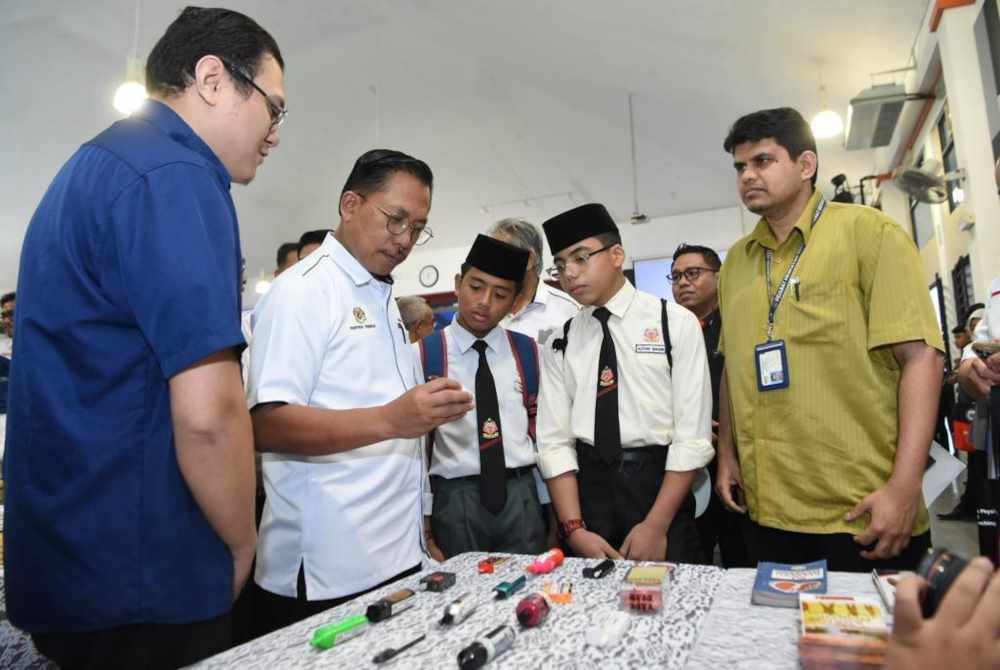 Azman (dua dari kiri) mengunjungi pameran rokok dan vape yang tersedia di Kolej Tingkatan Enman Desa Mahkota pada Rabu.