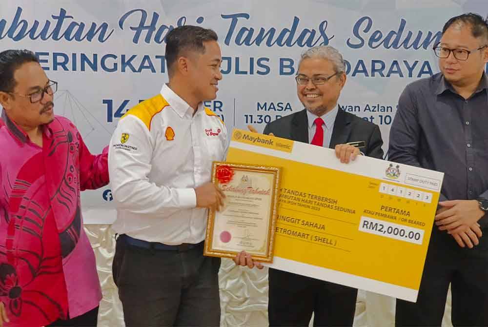 Rumaizi (dua dari kanan) menyampaikan anugerah kepada Bahakhi Petronart (Shell Jalan Hospital) (dua dari kiri) bagi kategori tandas stesen minyak terbersih pada sambutan Hari Tandas Sedunia 2023 peringkat MBI.