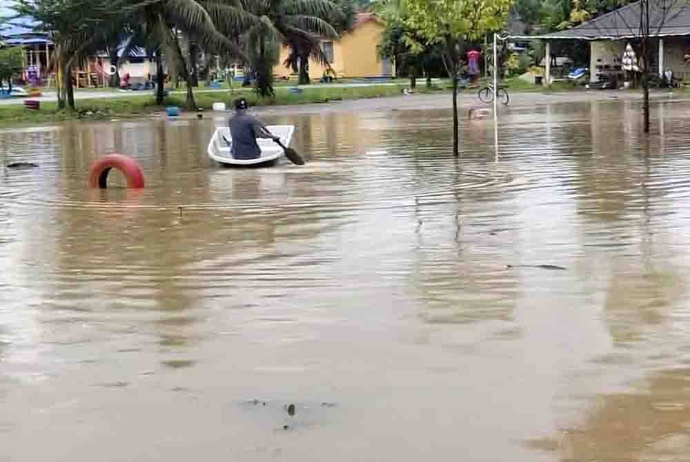 Seorang penduduk kayuh sampan ketika banjir landa Hulu Terengganu pada Khamis.