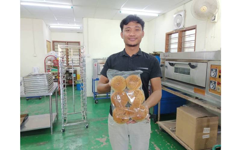 Muhamad Syirazi hasil produk roti burger yang dihasilkan di premisnya di Jalan Jenun, Pendang, Kedah.