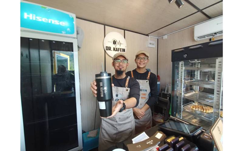 Muhammad Asyraf (kiri) menunjukkan tumbler jenama Dr. Kafien.
