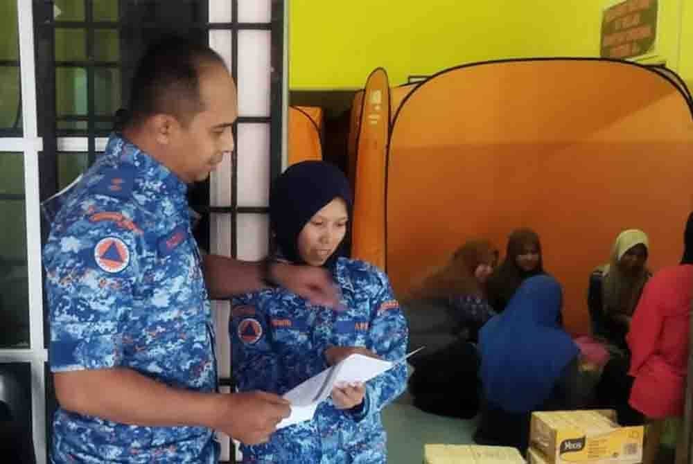 Anggota APM membuat pemeriksaan di PPS yang terjejas banjir di sekitar Kuala Krai. - Foto: APM