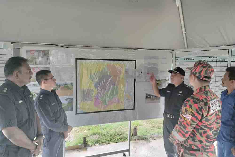 Bahrin (tiga dari kanan) memberikan penerangan kepada pasukan penyelamat berkaitan operasi mencari dan menyelamat seorang veteran komando yang dilaporkan hilang pada Khamis.