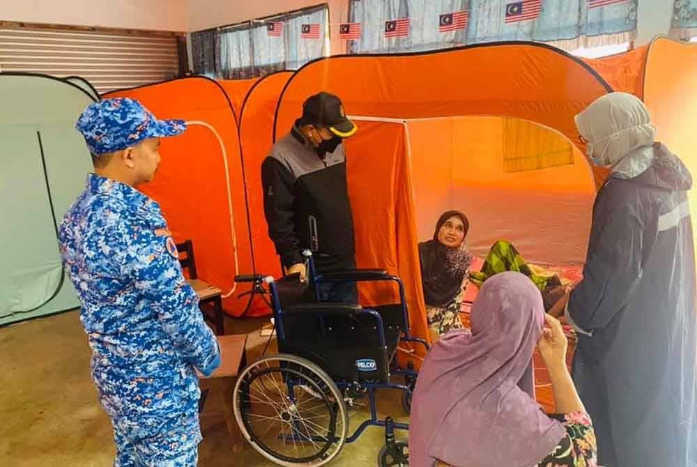 Kakitangan JKNK bertemu mangsa banjir di PPS untuk pemeriksaan kesihatan.