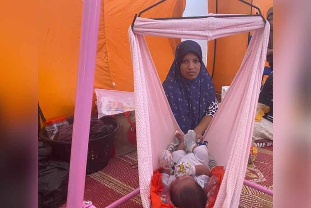Hasmawati terpaksa berjalan kaki sejauh 500 meter untuk berpindah di PPS Sekolah Menengah Ugama (A) Tarbiah Islamiah Kuala Kajang susulan banjir pada Sabtu.