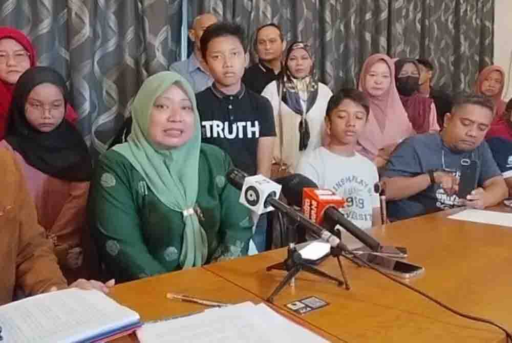 Suzana (kiri) bersama Ahmad Nabil (berdiri, tengah) pada sidang akhbar taklimat mengenai saman sivil berkenaan pada Sabtu.