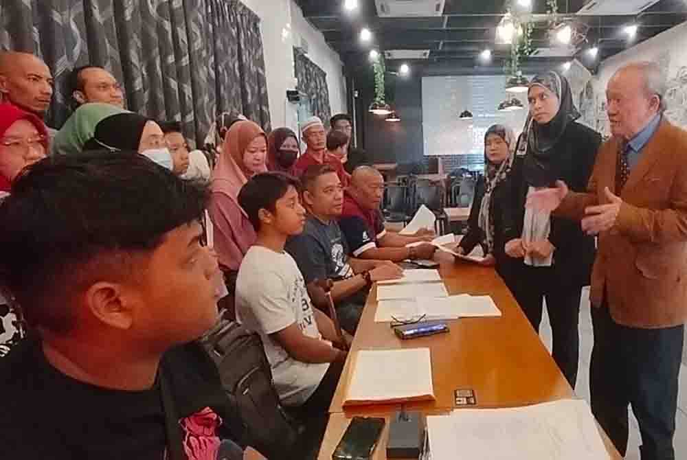 Kamaruddin ( kanan) berbincang mengenai saman sivil dengan mangsa pencemaran Sungai Kim Kim.