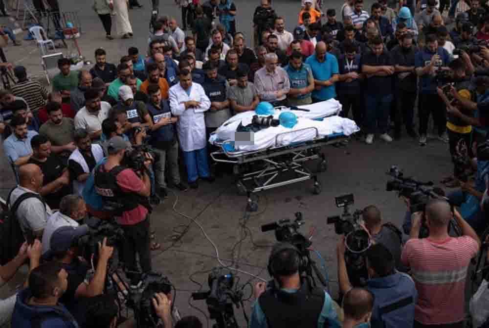Rakan media menunaikan solat jenazah untuk dua wartawan yang terkorban akibat serangan udara Israel pada 10 Oktober lalu. Gambar kecil: Samer