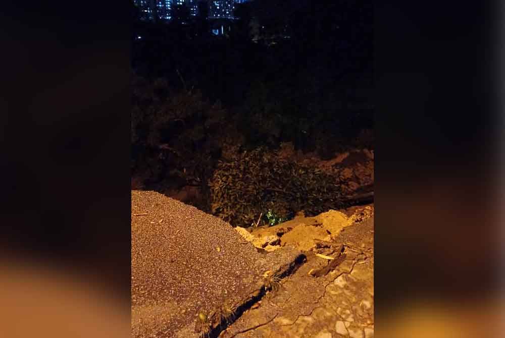 Keadaan tanah runtuh di hadapan sebuah daripada rumah teres di Jalan Wawasan di Puchong, Selangor pada Sabtu. Foto: JBPM Selangor