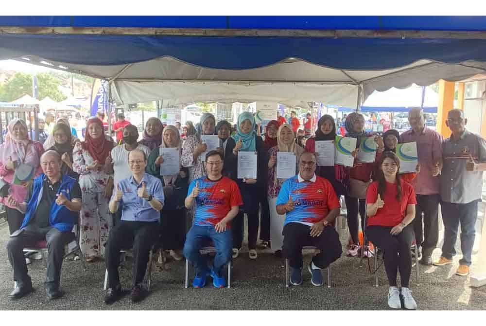 Jimmy (duduk, tengah) bersama sebahagian daripada 100 suri rumah yang menerima Sijil Skim Keselamatan Sosial Suri Rumah (SKSSR) tajaan Pusat Khidmat Parlimen Tebrau.
