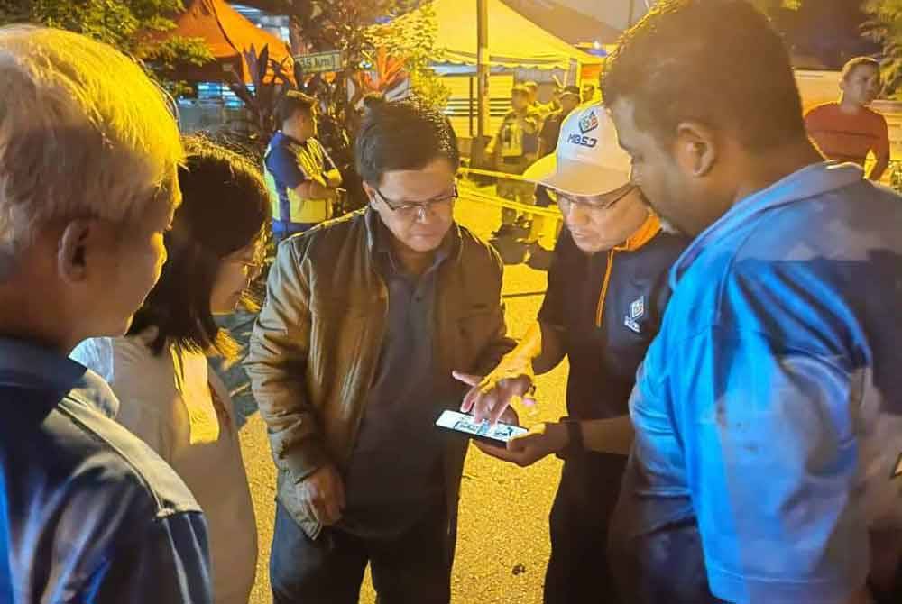 Mohd Fauzi (tengah) mendengar penerangan berkenaan situasi kejadian tanah runtuh yang berlaku pada Sabtu.