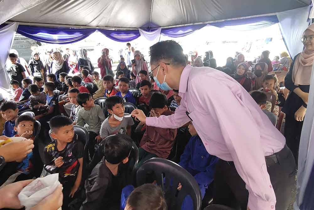 Setiausaha bahagian Pengurusan Zakat MAIDAM, Nazli Amirri Ngah (kanan) menyuapkan pulut kuning kepada peserta program mega sunaton di Klinik Hijraa Chendering, Kuala Terengganu.