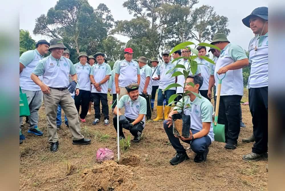 Mohd Uzir mendengar penerangan teknik penanaman pokok daripada wakil FRIM.