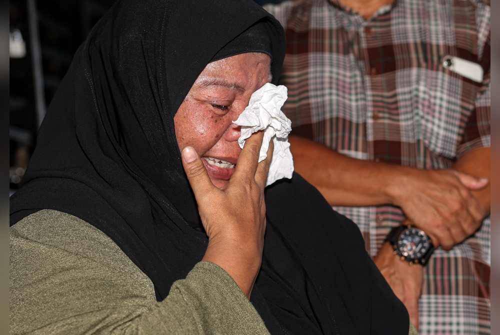 Mimi Julia tidak dapat menahan sebak ketika menjawab pertanyaan media di kediamannya di Taman Chepor Sentosa Chemor. - Foto Bernama