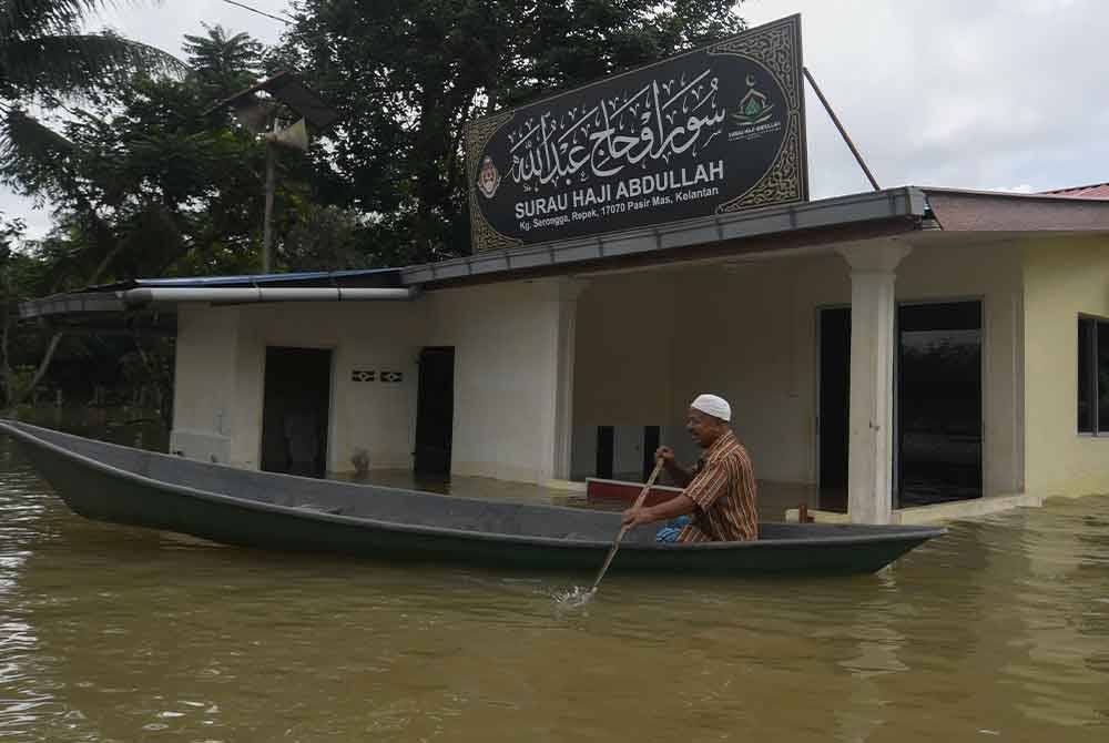 Penduduk menggunakan sampan melihat keadaan di sekitar kediamannya di Kampung Serongga yang dilanda banjir. - Foto Bernama