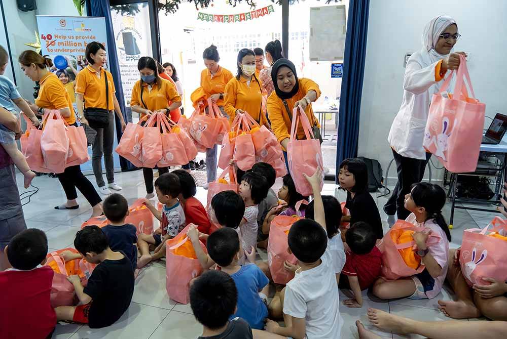 Kakitangan Guardian mengedarkan produk mandian kepada kanak-kanak Yayasan Sunbeams Home di Petaling Jaya, baru-baru ini.
