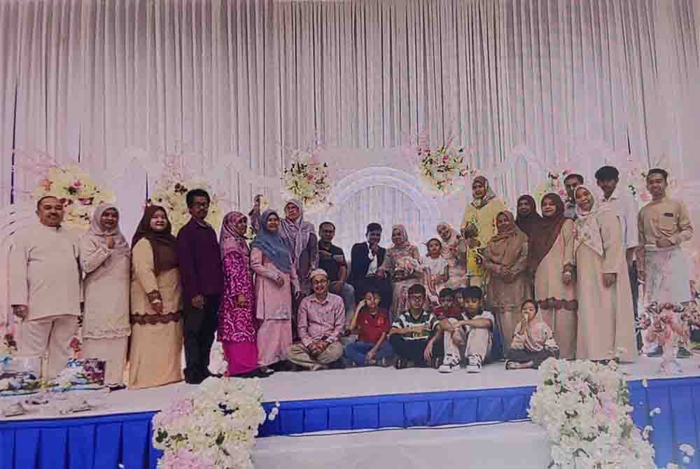 Ahli keluarga bergambar bersama pasangan pengantin pada majlis persandingan di Dewan Seri Bernam pada Sabtu.