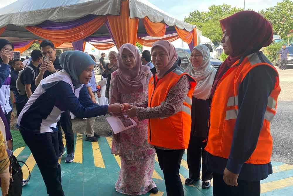 Nancy (dua dari kanan) tiba di depoh simpanan keperluan bencana di Taman Kemumin, Pengkalan Chepa, Kota Bharu.