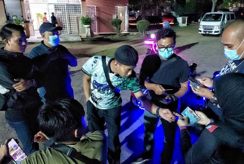 Orang ramai menunjukkan MyKad masing-masing untuk diperiksa JPN Melaka