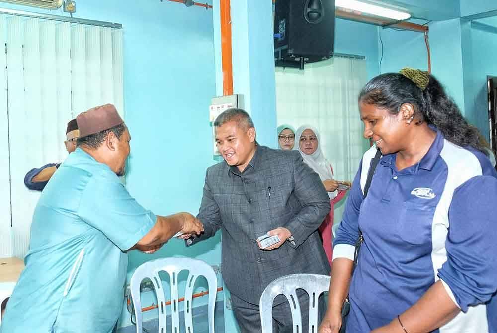 Rais (tengah) menyampaikan Sumbangan Zakat TM Melaka dan Japerun Paya Rumput di sini, pada Selasa.